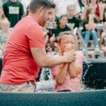 A joyful baptism event outdoors with a supportive church community.